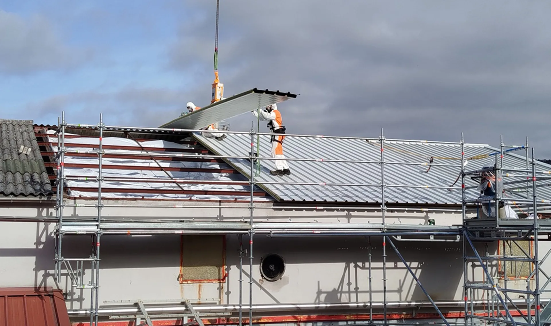 Dépose de bac acier amianté en toiture avec échafaudage et grue, chantier de désamiantage coordonné par Arkeom
